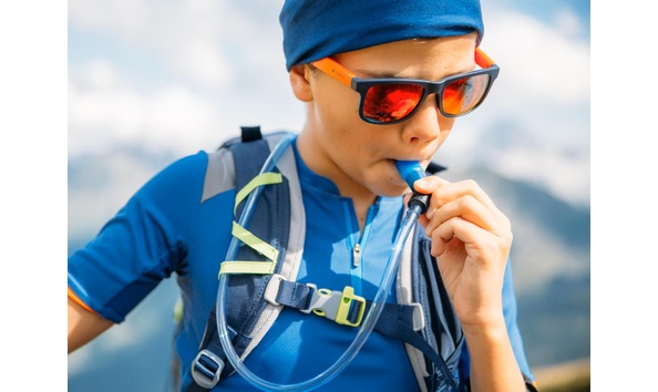 Big image young boy drinking from a hydration pack