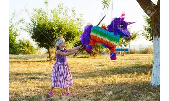 Big image 61886735 young girl at an outdoor party hitting a pinata celebrating a birthday 